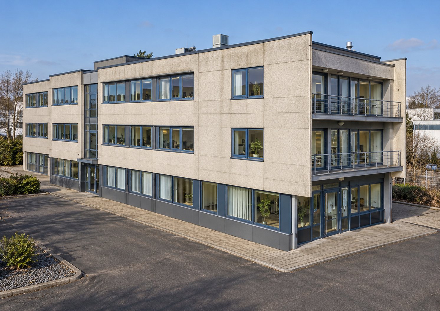 Dreigeschossiges Bürogebäude mit Flachdach und Parkplatz